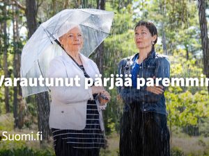 Kaksi naista vesisateessa. Toinen on varautunut sateenvarjolla, toinen ei. Varautunut pärjää paremmin.